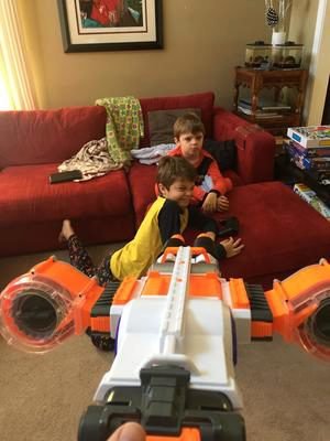 Kids playing with nerf gun on couch