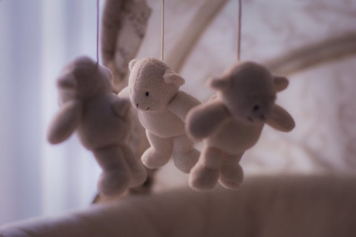 handingn teddy bears baby crib toys closeup shot