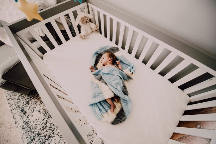 sleeping baby in a crib with toys